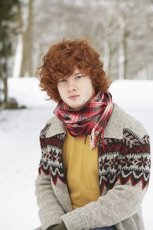 Teenage Boy Wearing Winter Clothes In Snowy Landscapeの写真素材