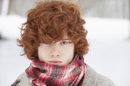 Teenage Boy Wearing Winter Clothes In Snowy Landscapeの写真素材