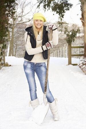 Teenage Girl Clearing Snow From Driveの写真素材