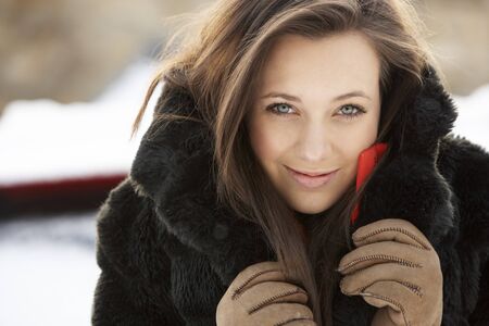 Close Up Of Teenage Girl Wearing Fur Coat In Snowy Landscapeの写真素材