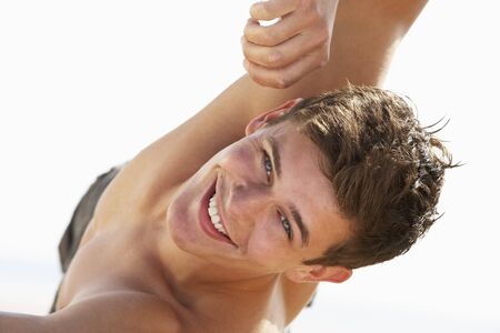 Teenage Boy Sitting On Beachの写真素材