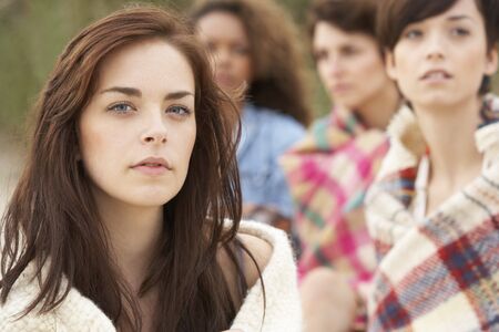 Close Up Of Group Of Girls Sitting On Beach Togetherの写真素材