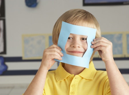Male Primary School Cutting Out Paper Shapes In Craft Lessonの写真素材