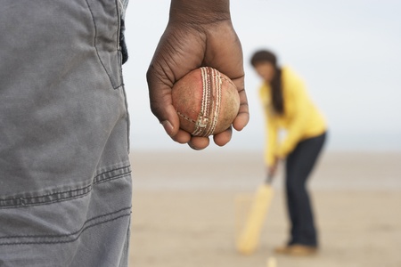 Young Couple Playing Cricket On Autumn Beach Holidayの写真素材