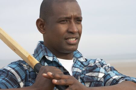 Young Man Playing Cricket On Autumn Beach Holiday