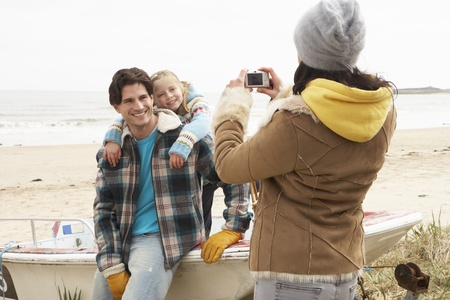 Mother Taking Family Photograph On Winter Beachの写真素材