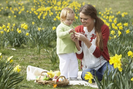 Mother And Daughter In Daffodil Field With Decorated Easter Eggsの写真素材