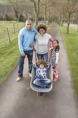 Family Having Ride In Wheelbarrow In Countrysideの写真素材