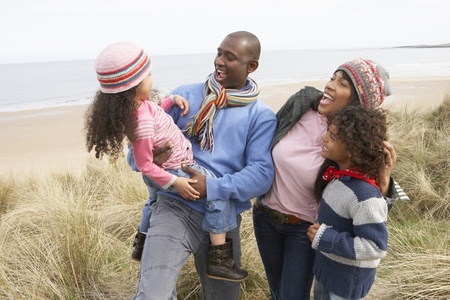 Family Walking Along Dunes On Winter Beachの写真素材