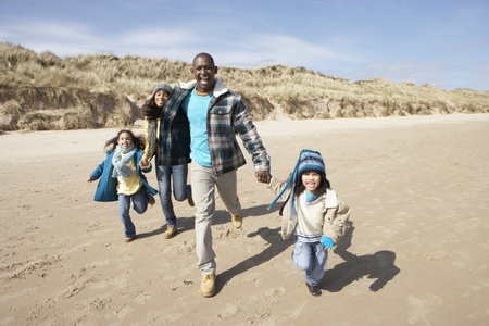 Family Running On Winter Beachの写真素材