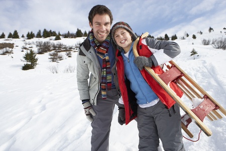 Young Father And Son In Snow With Sledの写真素材