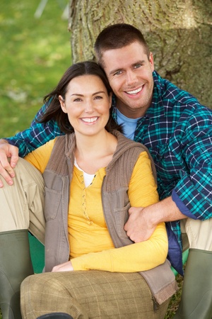 Couple sitting against tree trunkの写真素材