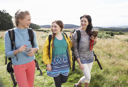 Group Of Teenage Girls Hiking In Countryside With Dogの写真素材