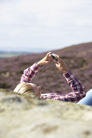 Teenage Girl Using Mobile Phone In Countrysideの写真素材