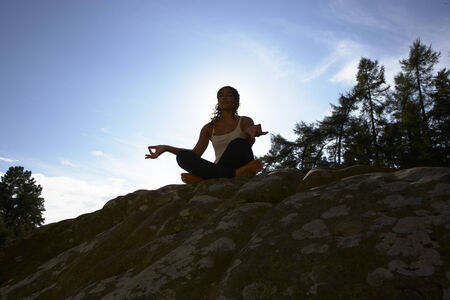 Silhouette Of Teenage Girl Meditating Outdoorsの写真素材