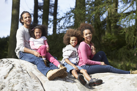 Family Group Sitting On Rock Togetherの写真素材