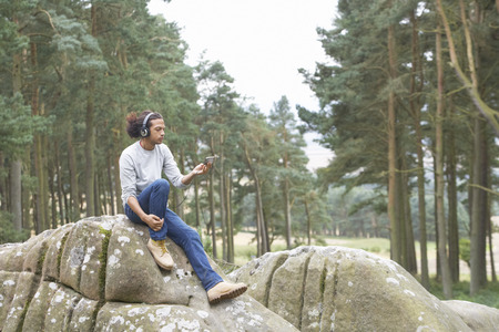 Man Listening To MP3 Player Whilst Hikingの写真素材