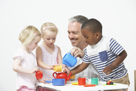 Pre School Children Enjoying Tea Party With Teacherの写真素材