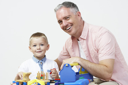 Teacher And Pre School Pupil Playing With Wooden Toolsの写真素材