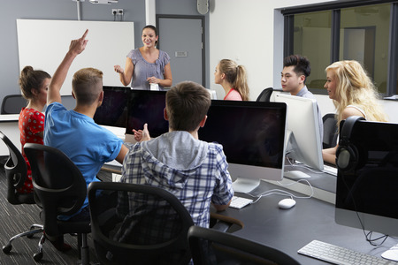 Group Of Students With Female Tutor In Computer Classの写真素材