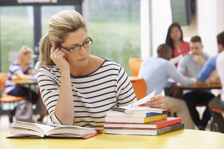 Mature Female Student Studying In Classroom With Booksの写真素材