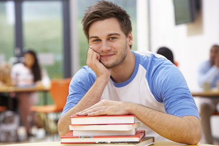 Male Student Studying In Classroom With Booksの写真素材
