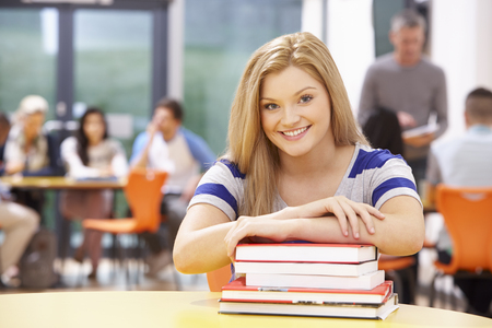 Female Teenage Student In Classroom With Booksの写真素材