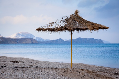 Straw umbrella on beach in winter, Koktebel, Crimeaの写真素材