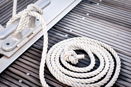 Mooring rope with a knotted end tied around a cleat  の写真素材