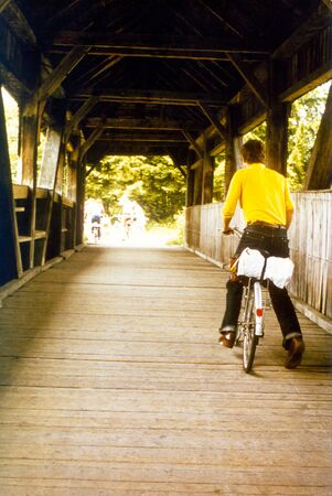 Man with a plastic bag on his carrier pushing his bike forwardの写真素材