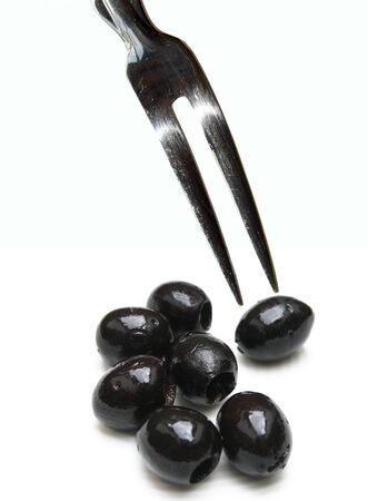 Fork with two tips over olives on white backgroundの写真素材