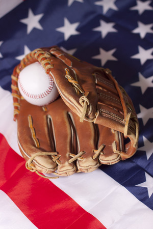 Baseball and glove on American flagの写真素材