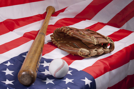 Baseball bat and glove on American flagの写真素材