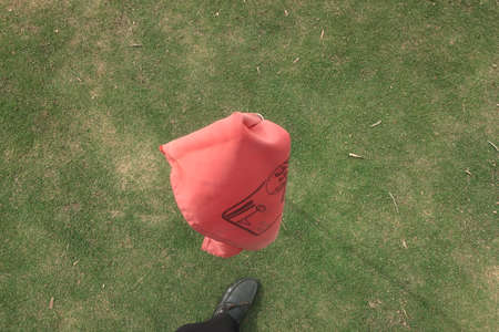 The scenery of a beautiful red flag at the start of golf tournament