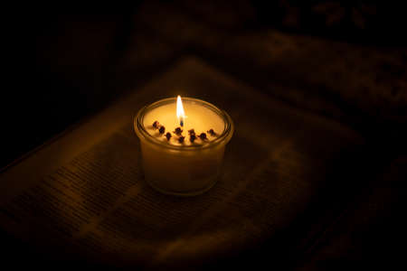Soy candle lights old book in the libraryの写真素材