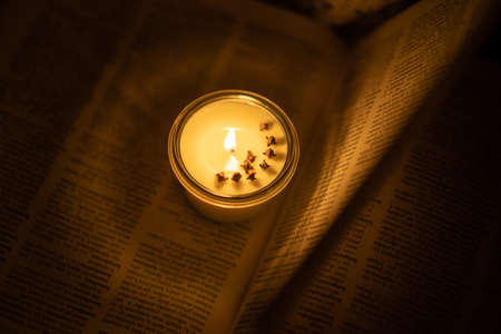 Soy candle lights old book in the library
