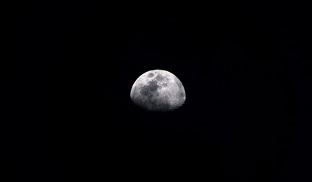 Earth's Moon Glowing On Black Background. Waning Gibbous moon / Waning means that it is getting smaller. Gibbous refers to the shape, which is less than the full circle of a Full Moonの写真素材