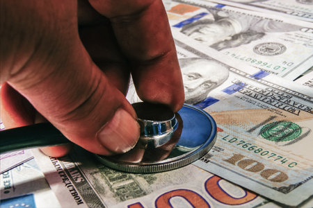 A stethoscope in the hands of a doctor listening to the breathing of US dollars.の写真素材