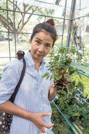 woman choose some plant to buy in the outdoor shop with happy emotion の写真素材