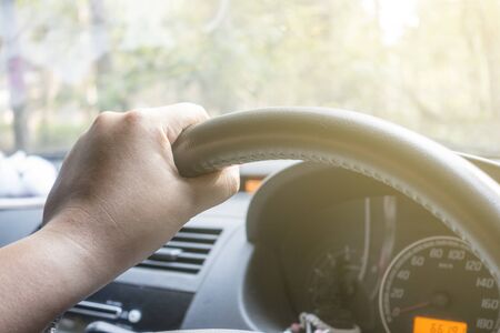 young man driving car with one hand 
