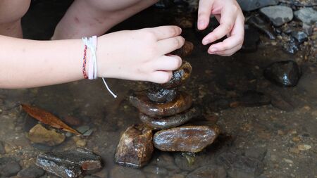 young man sort stone in the river の写真素材