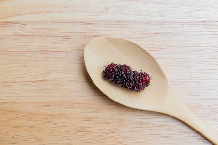 Mulberry in spoon on a wood plant, mulberry have Red and black color and  berry fruit good healthの写真素材
