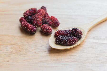 Mulberry spoon and fork on a wood plant, mulberry have Red and black color and  berry fruit good healthの写真素材