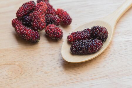 Mulberry spoon and fork on a wood plant, mulberry have Red and black color and  berry fruit good healthの写真素材