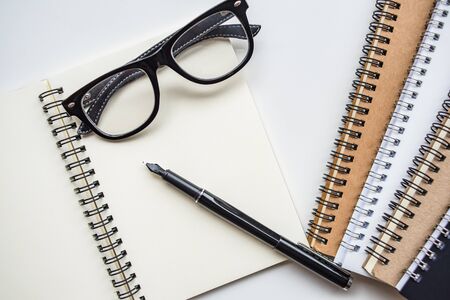 mock up top view notebooks,  glasses and pen on background white tableの写真素材