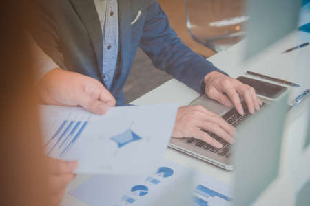 two young businessmen discussing project at meeting with laptop and smart phone on tableの写真素材