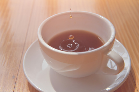good time or morning Tea drop in a cup on the wooden table. soft focusの写真素材