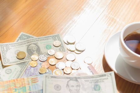 make money tip dollar or euro for travel and tea cup near on the wooden tableの写真素材
