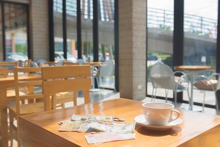 make money tip dollar or euro for travel and tea cup near on the wooden tableの写真素材