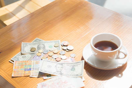 make money tip dollar or euro for travel and tea cup near on the wooden tableの写真素材